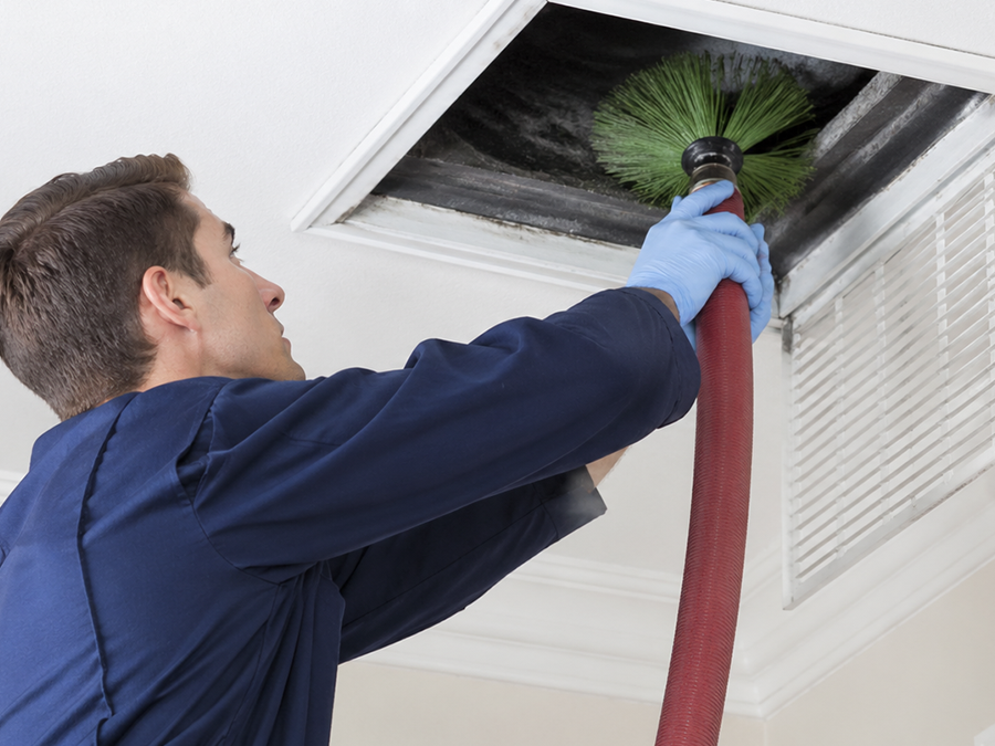 Air vent cleaning technician in blue uniform