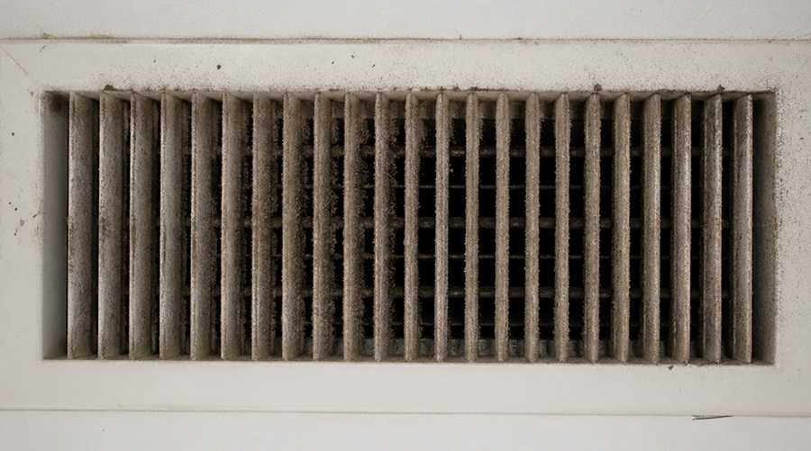 Dirty air vent covered with dust and debris buildup inside home ceiling