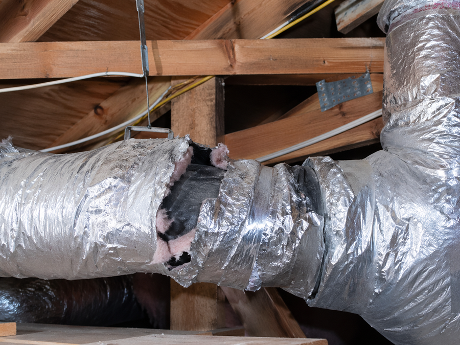 Duct leaks in attic with damaged HVAC insulation and exposed air duct system